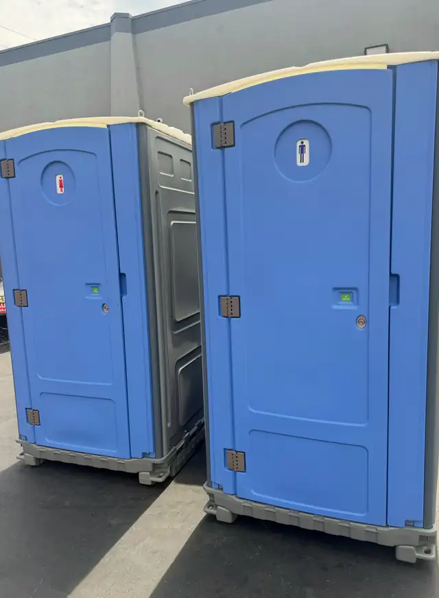 Two blue standard porta potties ready for delivery